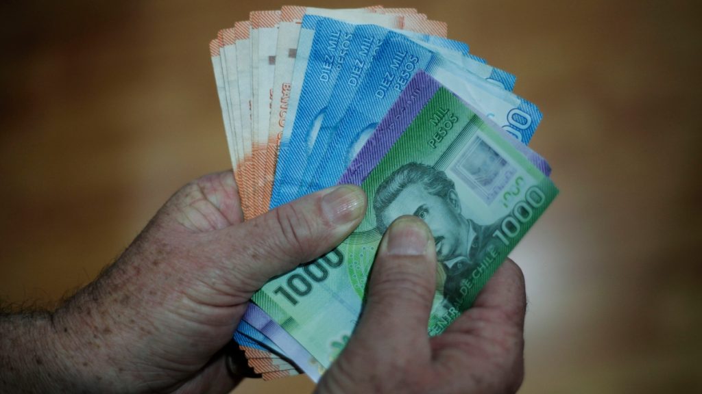 Una persona revisando su cuenta bancaria en un celular, simbolizando el pago de bonos estatales.