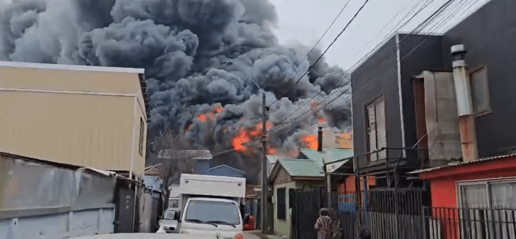 Gigantesca columna de humo negro emanando del gran incendio en una bodega del sector Chillancito, en Concepción.