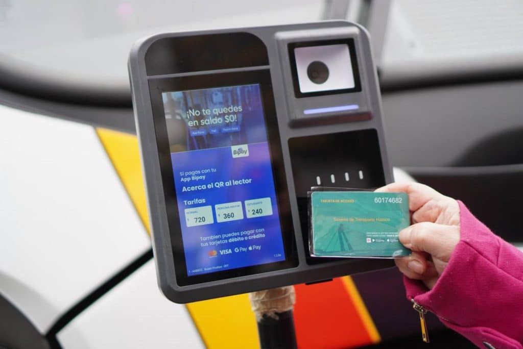 Persona pagando el pasaje del transporte público en el Gran Concepción con una tarjeta bancaria en un validador electrónico.