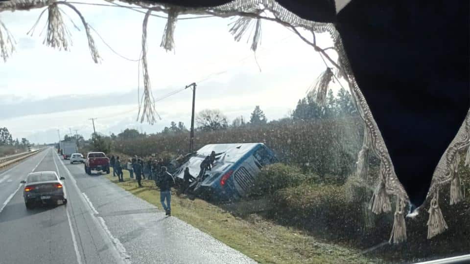 Bus de la empresa EME Bus volcado en una zanja en la Ruta 5 Sur, mientras equipos de emergencia trabajan en el fatal accidente en San Gregorio.