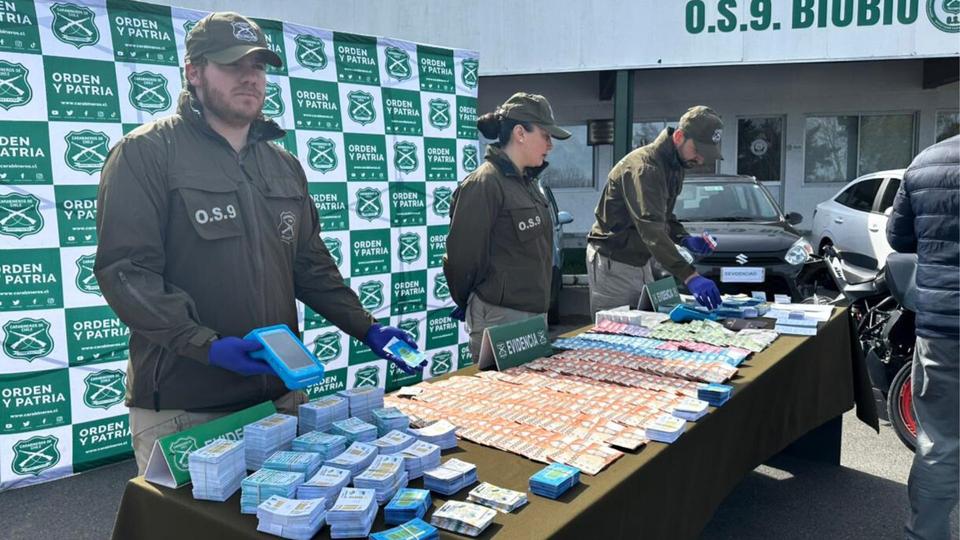 Billetes-de-dolares-y-pesos-chilenos-en-una-mesa-con-celulares.